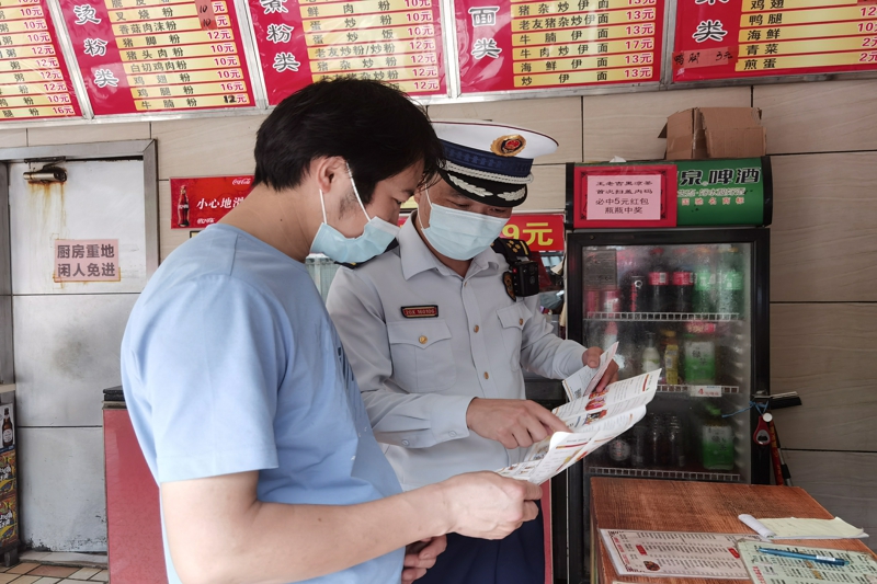 消防检查人员向店主宣传消防安全知识.jpg