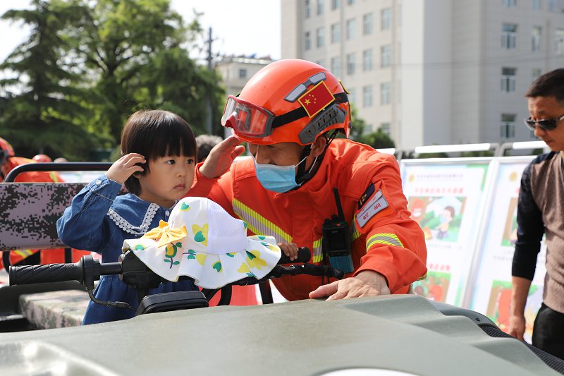 5月20日，在平凉市2022年全民义务植树暨世界野生动植物和国际生物多样性保护宣传活动中，崆峒区森林消防大队消防员与萌娃现场互动。（柳晓飞-摄）.JPG