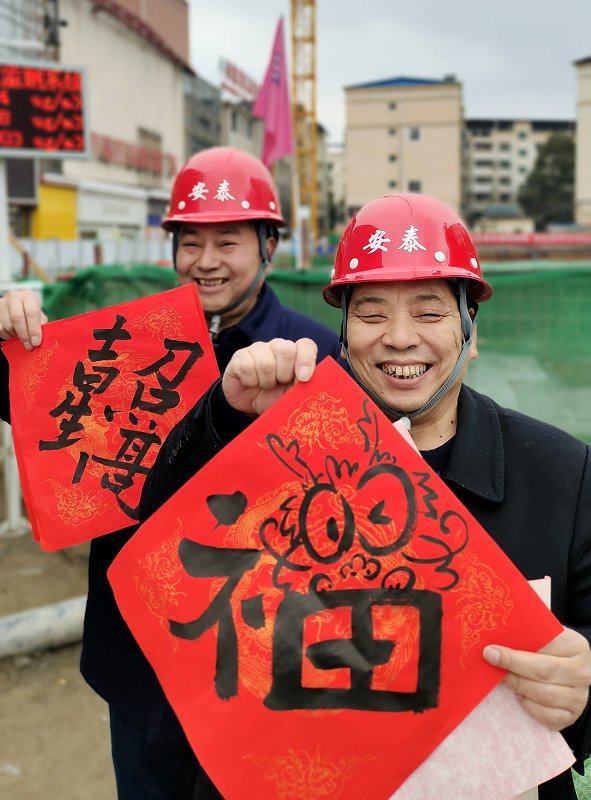 （1）2月5日，宁强县新华书店建设工地上的工人在展示他们领到的龙年新春福字。黎德华 摄.jpg